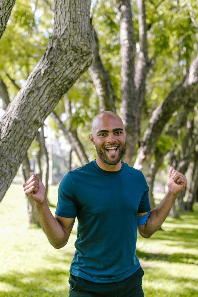 Vibrant scene of a joyful man in a park during daytime, exuding happiness and energy.
